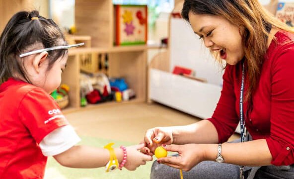 Teacher playing toys with girl